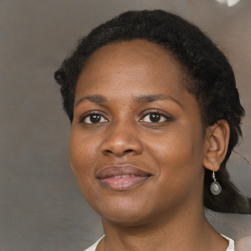 Joyful black young-adult female with short  black hair and brown eyes