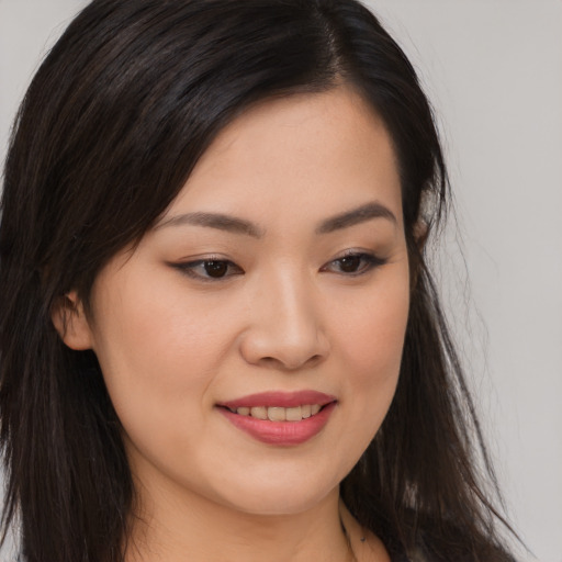 Joyful asian young-adult female with long  brown hair and brown eyes