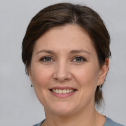 Joyful white adult female with medium  brown hair and grey eyes