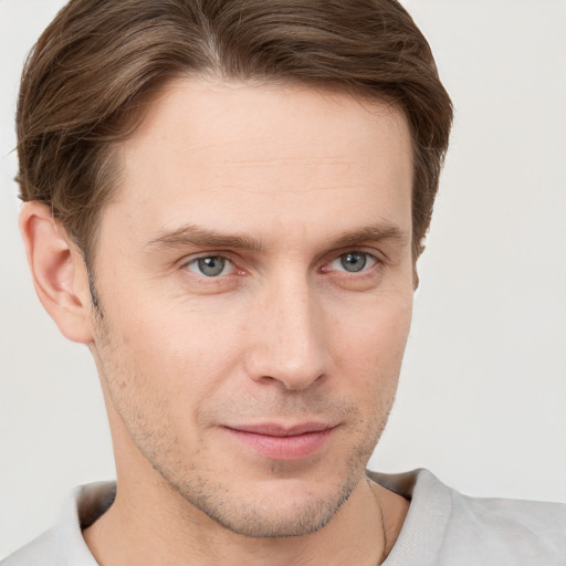 Joyful white young-adult male with short  brown hair and grey eyes