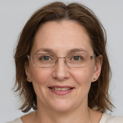 Joyful white adult female with medium  brown hair and blue eyes