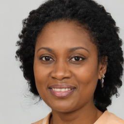 Joyful black adult female with medium  brown hair and brown eyes