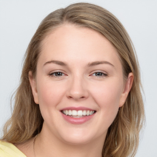 Joyful white young-adult female with long  brown hair and blue eyes