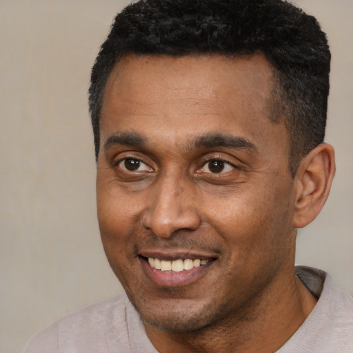 Joyful latino adult male with short  black hair and brown eyes
