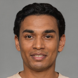 Joyful latino young-adult male with short  black hair and brown eyes