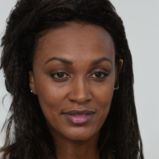 Joyful black young-adult female with long  brown hair and brown eyes