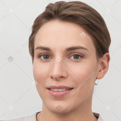 Joyful white young-adult female with short  brown hair and grey eyes