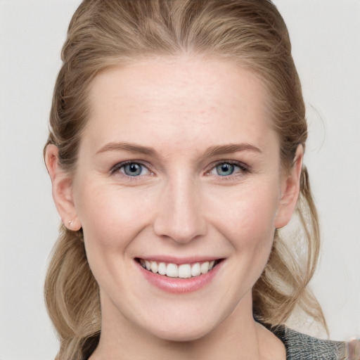 Joyful white young-adult female with medium  brown hair and blue eyes