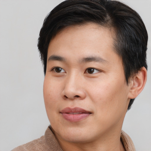 Joyful asian young-adult male with short  brown hair and brown eyes