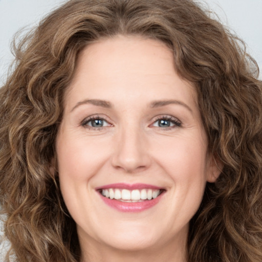 Joyful white young-adult female with long  brown hair and green eyes