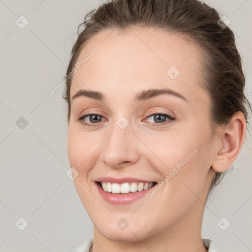 Joyful white young-adult female with medium  brown hair and grey eyes