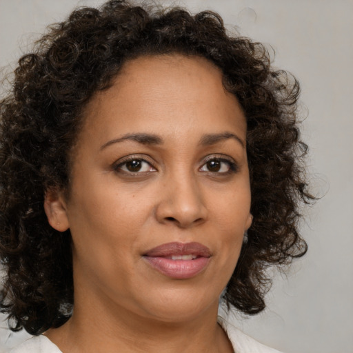 Joyful black young-adult female with medium  brown hair and brown eyes