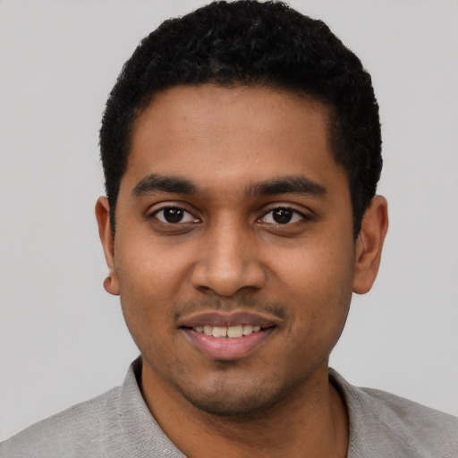 Joyful black young-adult male with short  black hair and brown eyes