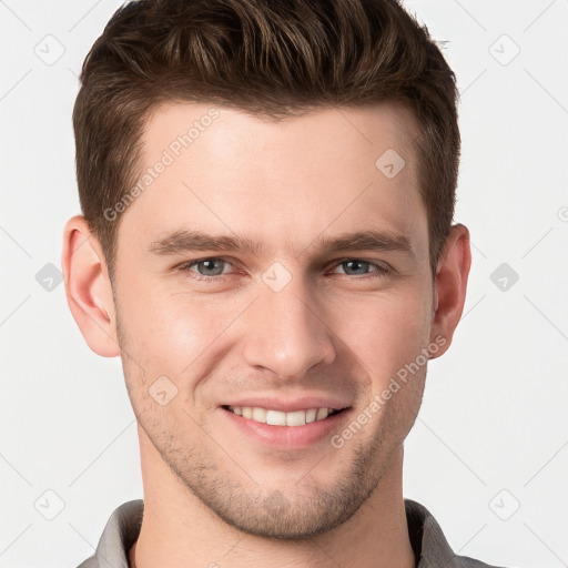 Joyful white young-adult male with short  brown hair and grey eyes