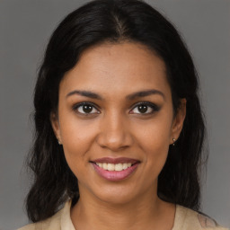 Joyful black young-adult female with long  brown hair and brown eyes