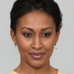 Joyful black young-adult female with short  brown hair and brown eyes