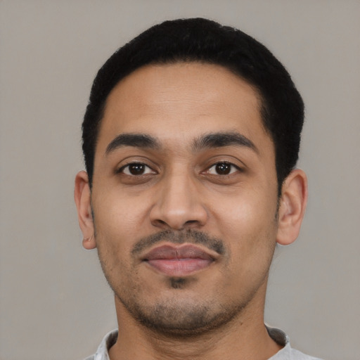 Joyful latino young-adult male with short  black hair and brown eyes