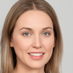 Joyful white young-adult female with long  brown hair and green eyes