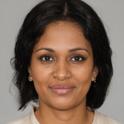 Joyful black young-adult female with medium  brown hair and brown eyes