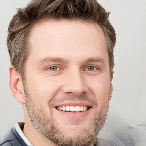 Joyful white young-adult male with short  brown hair and grey eyes