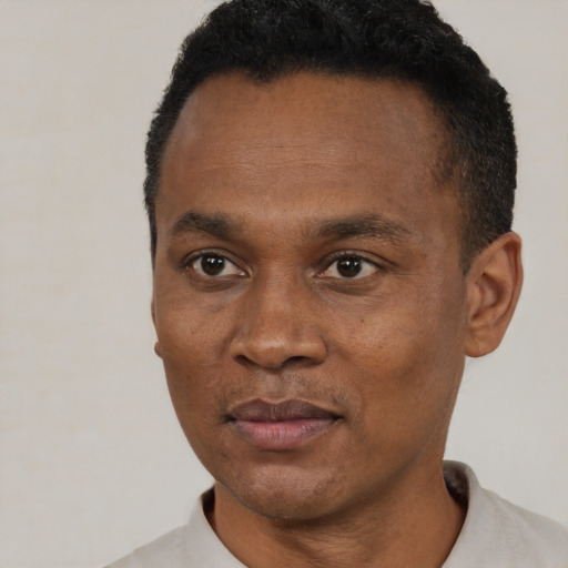Joyful black young-adult male with short  black hair and brown eyes