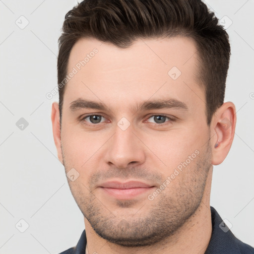 Joyful white young-adult male with short  brown hair and brown eyes