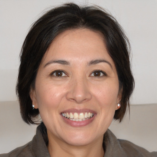 Joyful white adult female with medium  brown hair and brown eyes