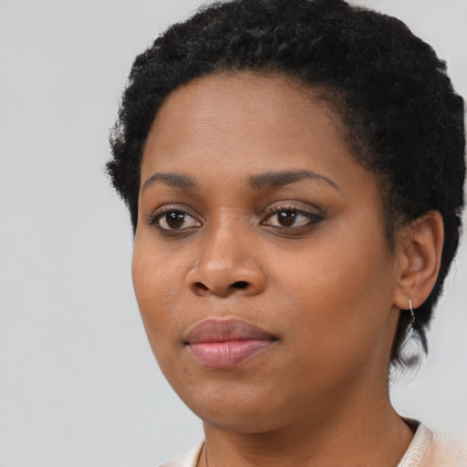 Joyful black young-adult female with short  black hair and brown eyes