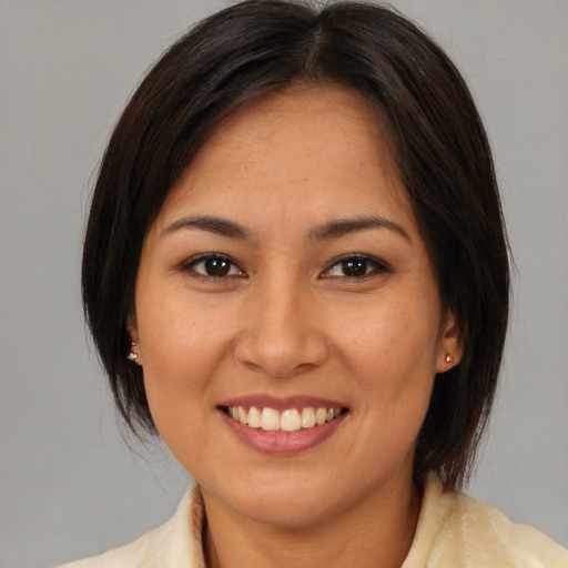 Joyful latino young-adult female with medium  brown hair and brown eyes