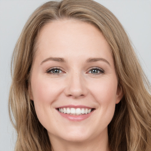 Joyful white young-adult female with long  brown hair and blue eyes