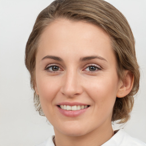 Joyful white young-adult female with medium  brown hair and grey eyes