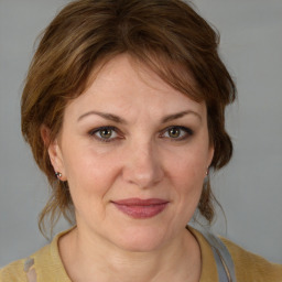 Joyful white adult female with medium  brown hair and blue eyes