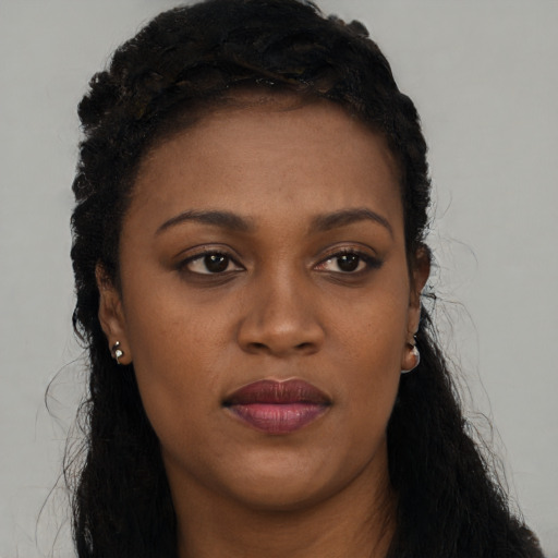 Joyful black young-adult female with long  black hair and brown eyes