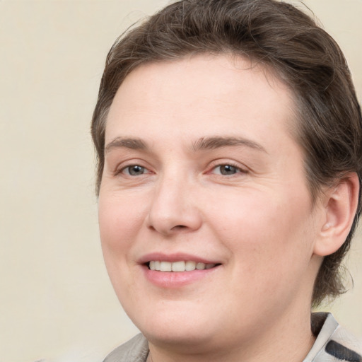 Joyful white young-adult female with medium  brown hair and grey eyes