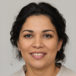 Joyful latino adult female with medium  brown hair and brown eyes