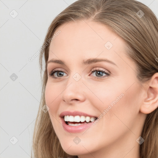 Joyful white young-adult female with long  brown hair and blue eyes