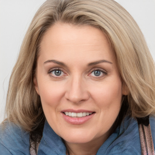 Joyful white adult female with medium  brown hair and blue eyes