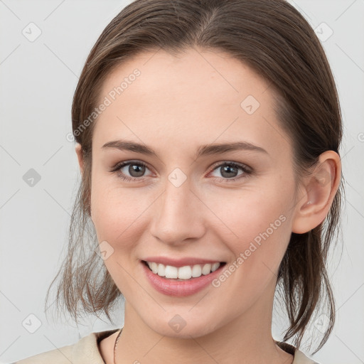 Joyful white young-adult female with medium  brown hair and grey eyes