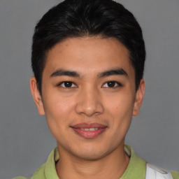 Joyful latino young-adult male with short  brown hair and brown eyes