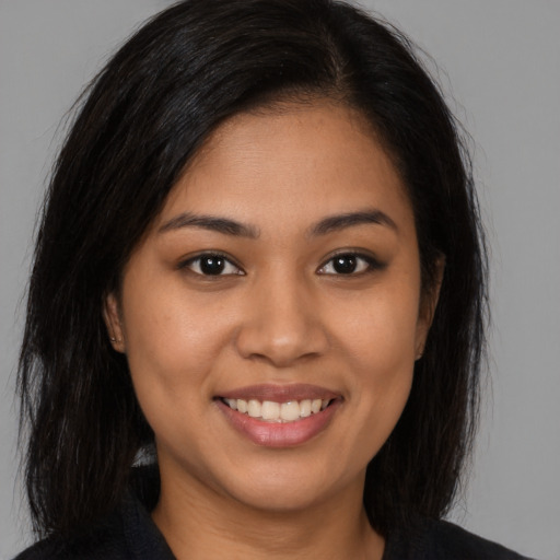 Joyful latino young-adult female with long  brown hair and brown eyes