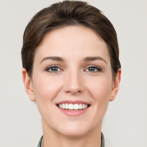 Joyful white young-adult female with short  brown hair and grey eyes