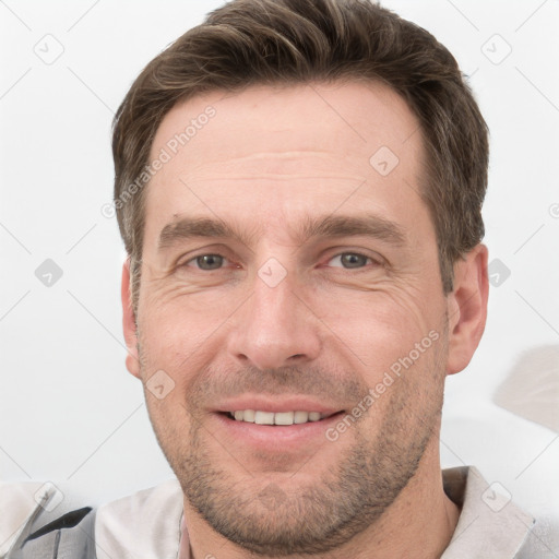 Joyful white adult male with short  brown hair and grey eyes