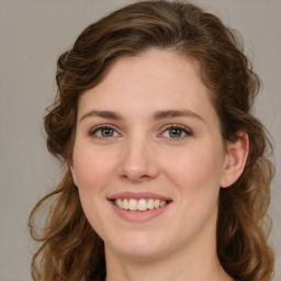 Joyful white young-adult female with medium  brown hair and green eyes