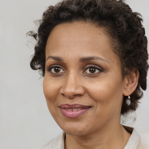Joyful black adult female with medium  brown hair and brown eyes