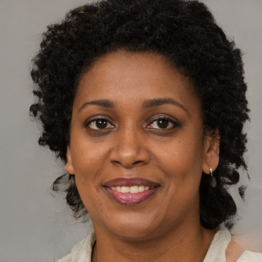 Joyful black adult female with medium  brown hair and brown eyes