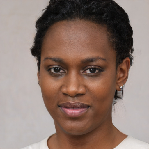 Joyful black young-adult female with short  black hair and brown eyes