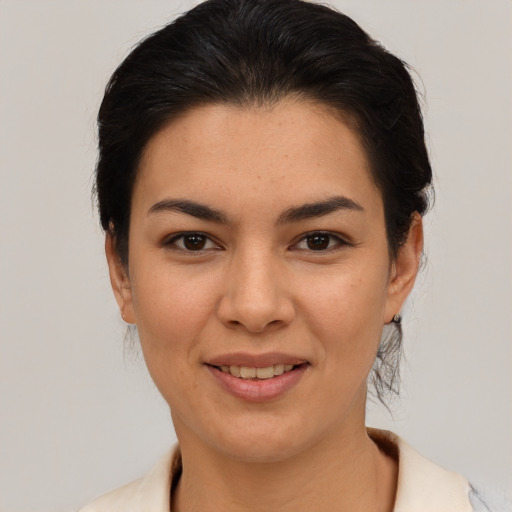 Joyful latino young-adult female with medium  brown hair and brown eyes