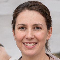 Joyful white young-adult female with medium  brown hair and grey eyes