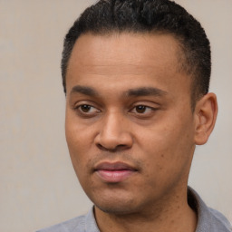 Joyful latino young-adult male with short  black hair and brown eyes