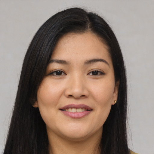 Joyful asian young-adult female with long  brown hair and brown eyes